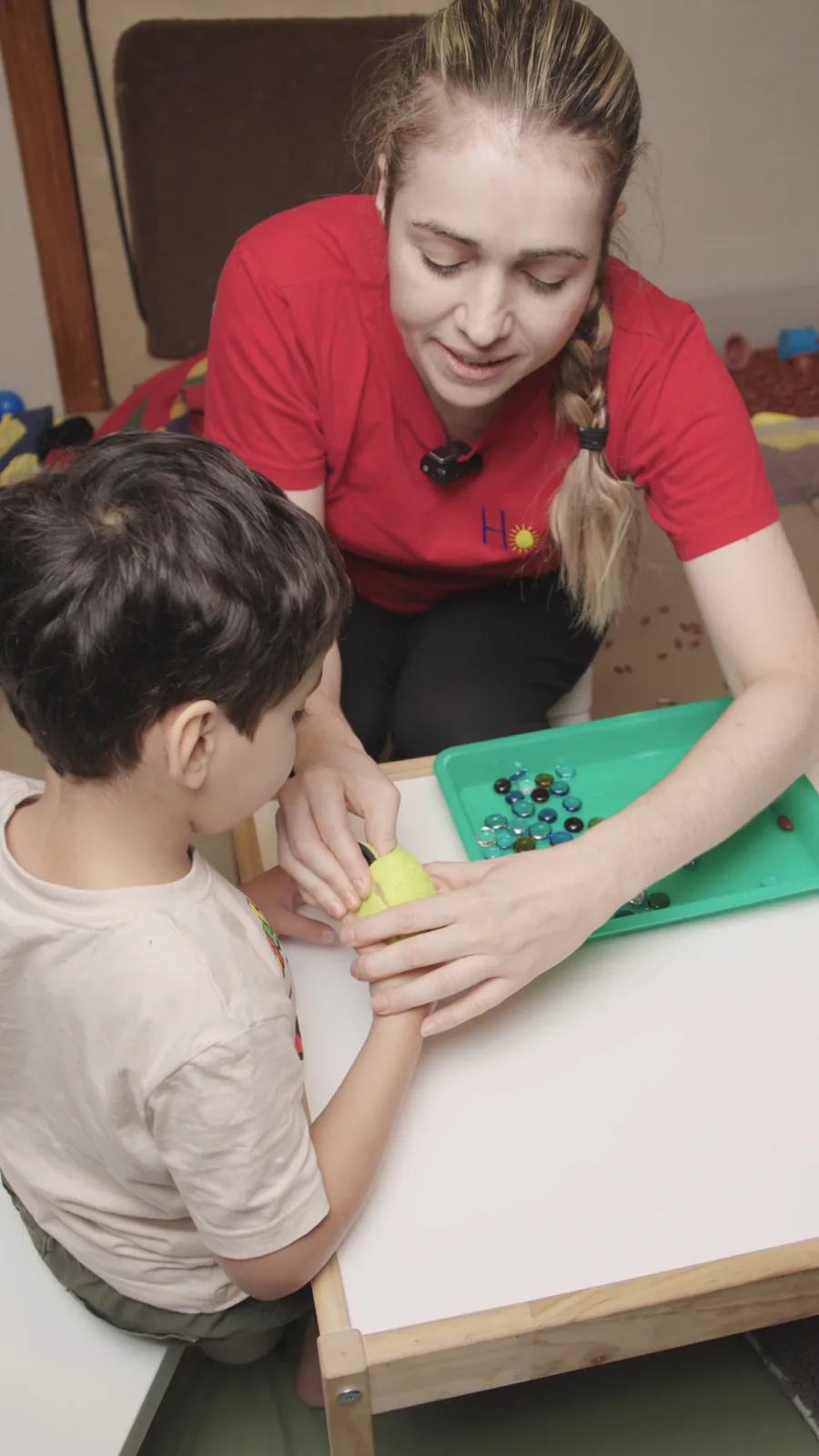 A therapist guides a child through a tabletop activity