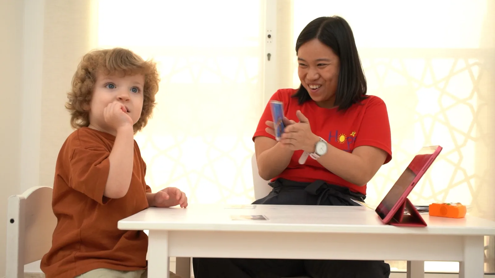 A Hope therapist and a young child laughing together during a tabletop session
