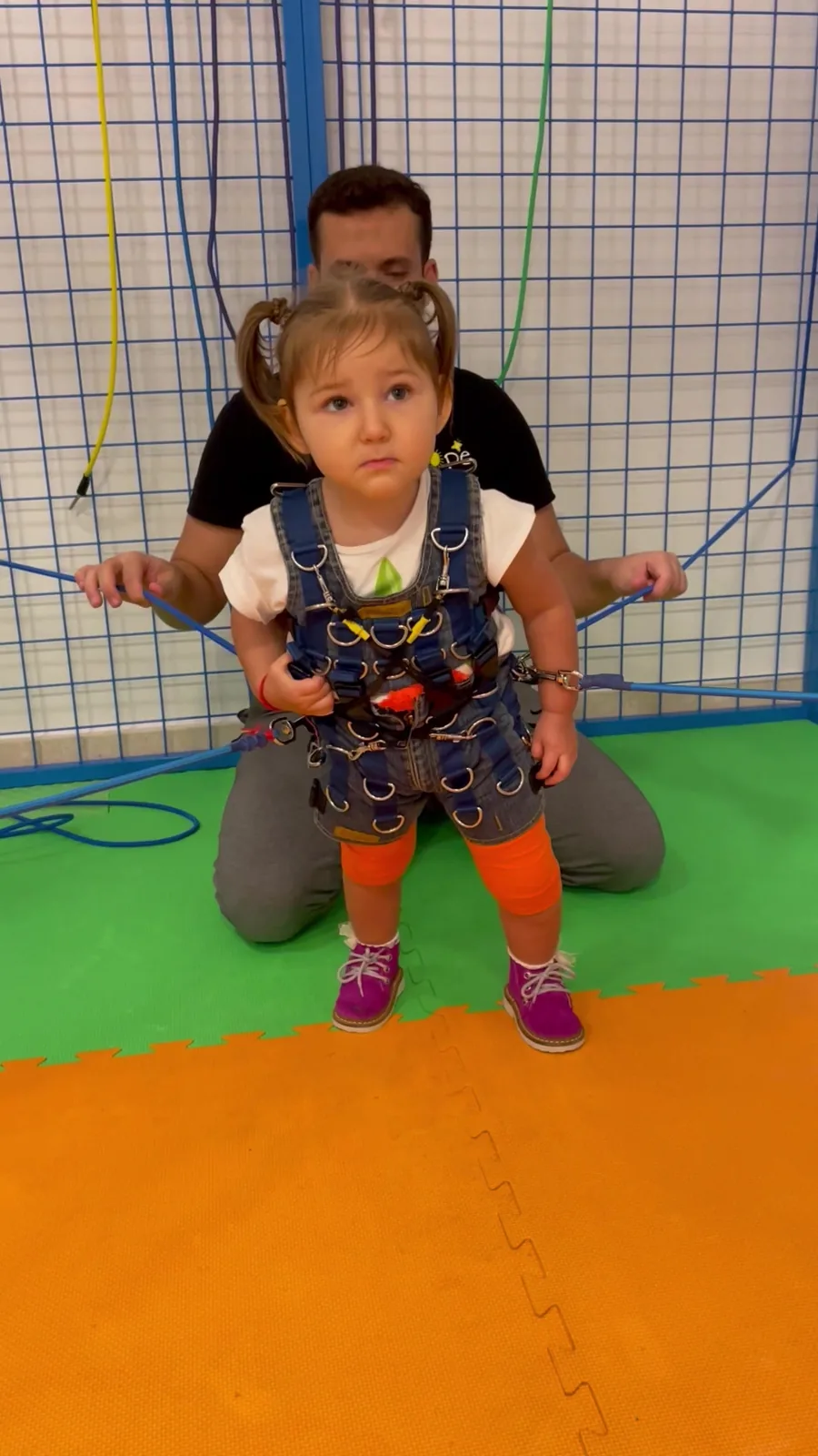 A child uses a therapy suit with support from a therapist