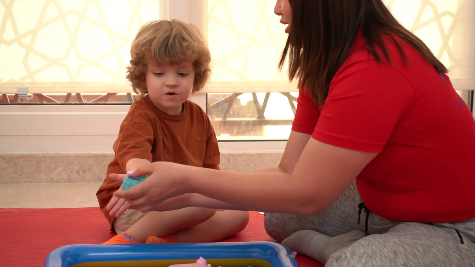 A therapist and child explore a sensory tub