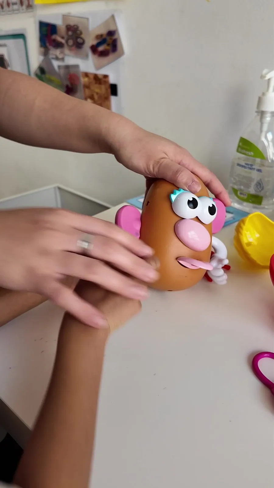 A child and therapist play with a toy at the table
