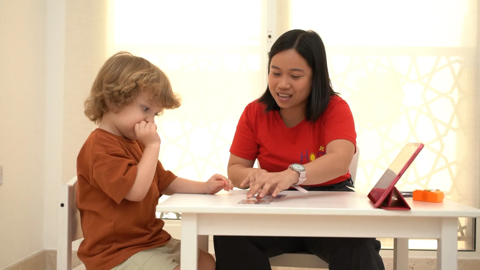 A Hope therapist going through picture cards with a young boy at a table