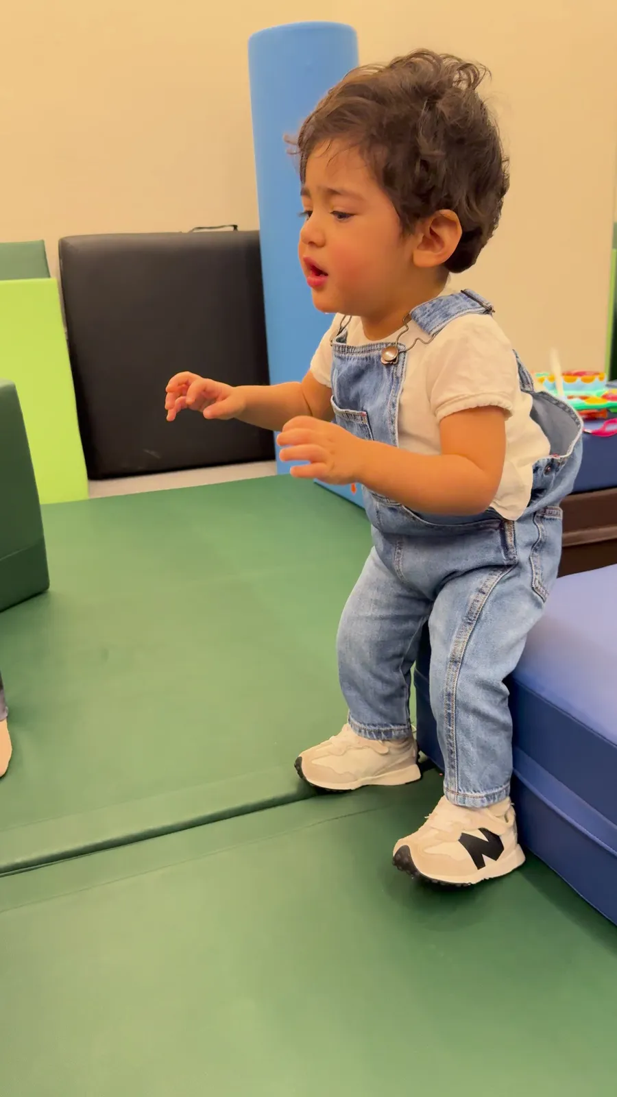 A toddler stands and explores during a therapy session