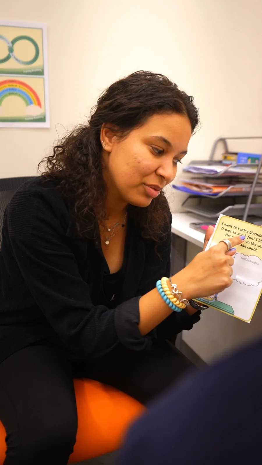 A therapist points to a picture book during a session