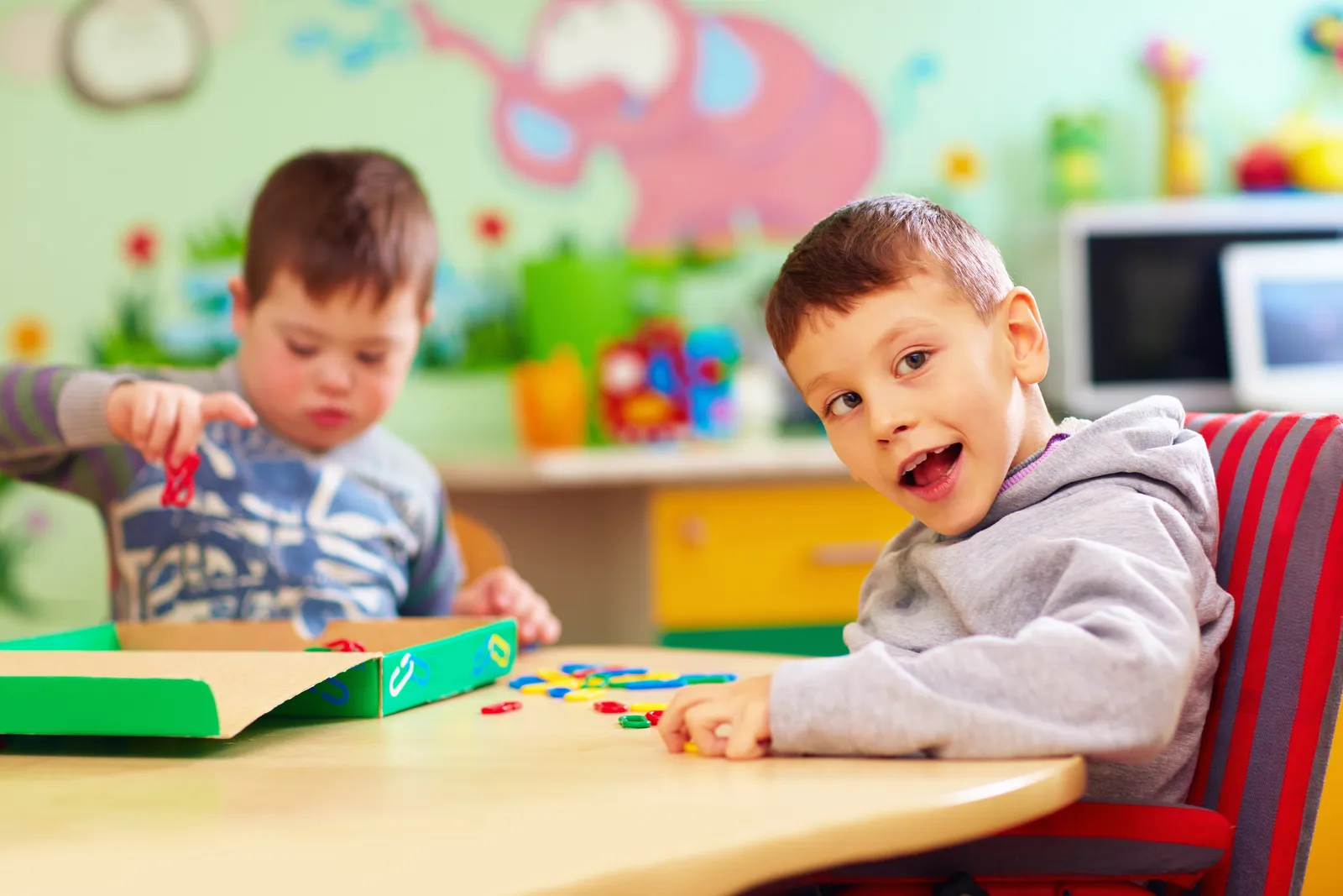 Two boys play a game at a classroom table
