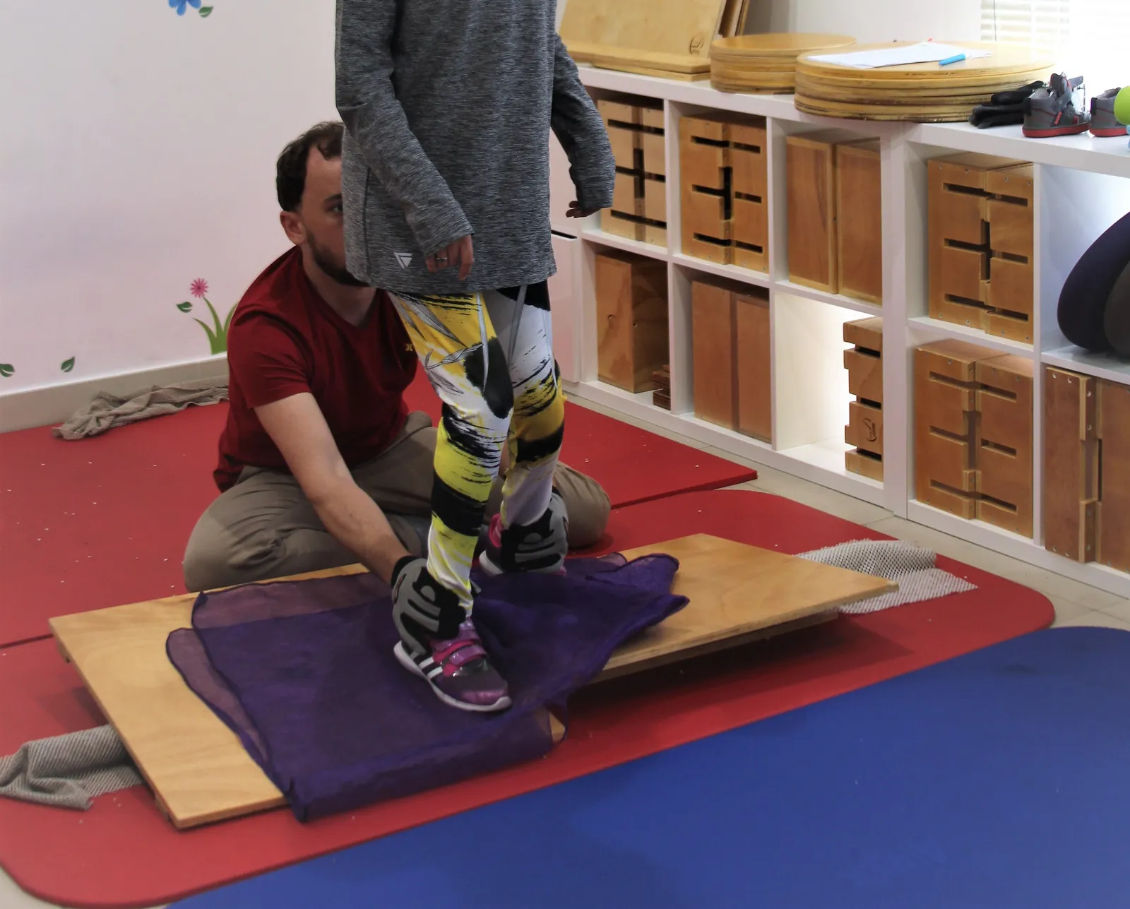 A therapist supports a child standing during a CME exercise