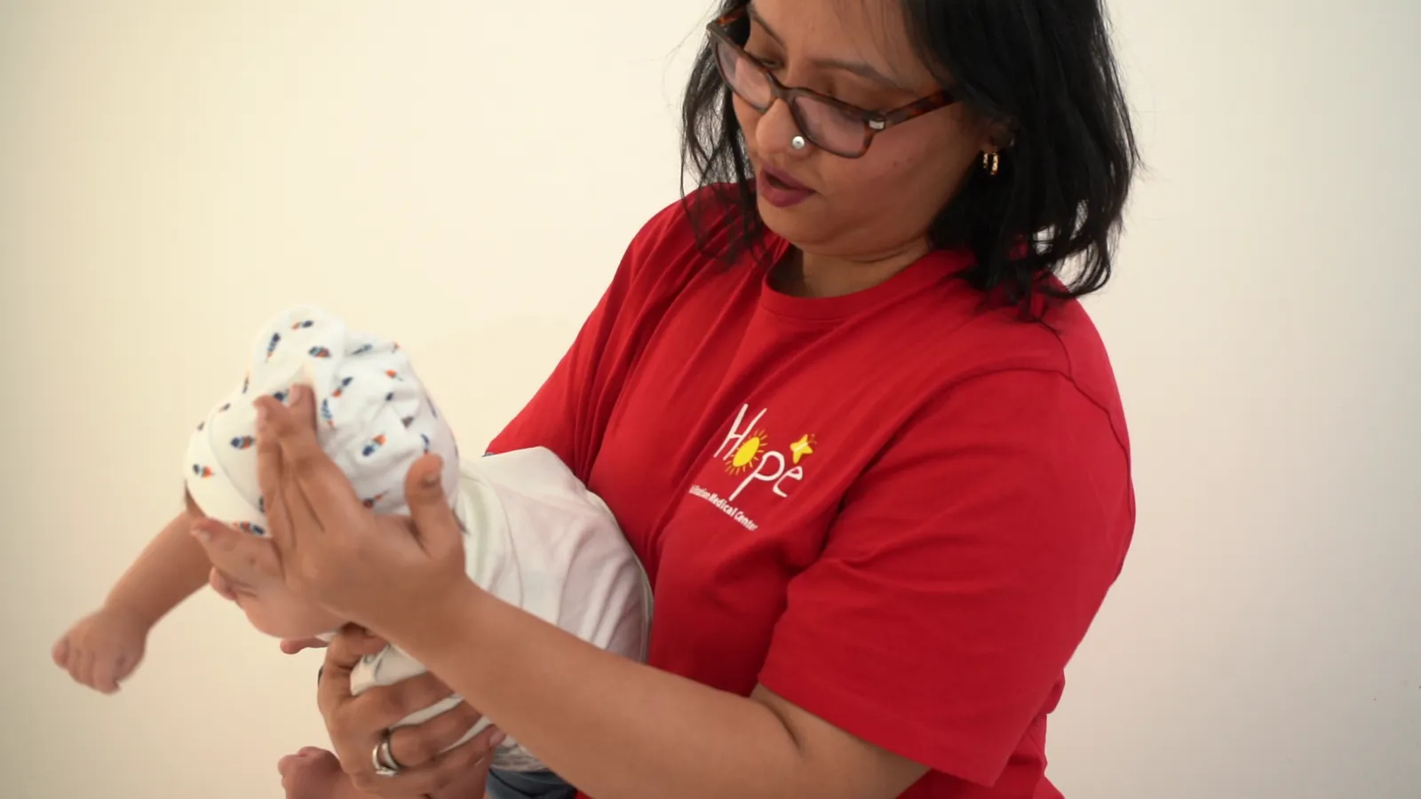 A therapist holds and supports a baby during early intervention