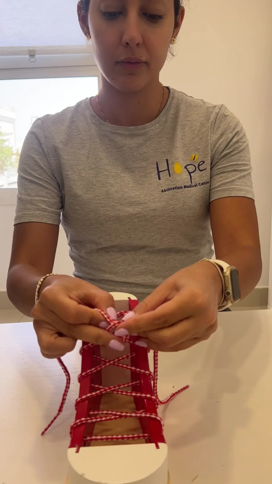 A child practices tying shoelaces